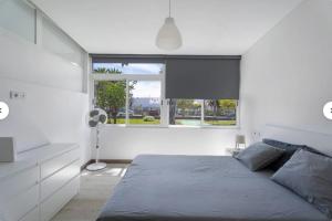 Un dormitorio con una cama y una ventana grande. en costa silencio, en Arona 18 fotos más