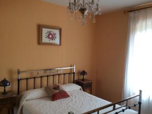 a bedroom with a bed and a chandelier at La Abuela Maye y Me in Carrión de los Condes