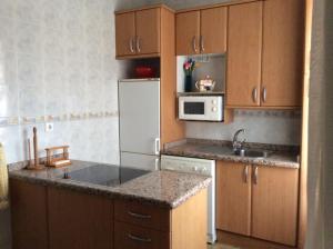 a kitchen with a white refrigerator and a sink at La Abuela Maye y Me in Carrión de los Condes +14 photos