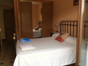 a bedroom with a large white bed with a mirror at La Abuela Maye y Me in Carrión de los Condes