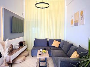 a living room with a blue couch and a table at BLUE - Seaview Loft Apartment in Amfilochia