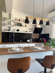 a kitchen with a counter with two chairs and lights at Panoramic Seaview Blue Nest - Stylish Getaway in Amfilochía