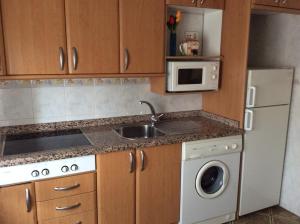 a kitchen with a sink and a microwave at La Abuela Maye y Me in Carrión de los Condes