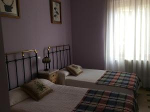 1 dormitorio con 2 camas y ventana en La Abuela Maye y Me en Carrión de los Condes