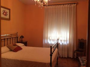 a bedroom with two beds and a window with a chandelier at La Abuela Maye y Me in Carrión de los Condes