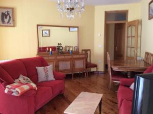 a living room with a red couch and a table at La Abuela Maye y Me in Carrión de los Condes