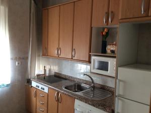 a kitchen with a sink and a microwave at La Abuela Maye y Me in Carrión de los Condes