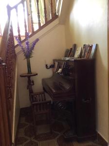 a stairway with a piano and a vase of flowers at La Abuela Maye y Me in Carrión de los Condes