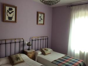 a bedroom with two beds and a window at La Abuela Maye y Me in Carrión de los Condes