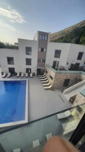 a swimming pool in front of a building at Apartment Cica in Igalo