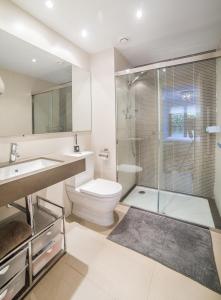 シッチェスにあるLuxury Apartment in Sitges Cityのバスルーム(トイレ、ガラス張りのシャワー付)
