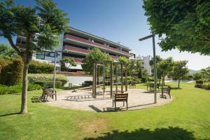 a park with benches in front of a building at Luxury Apartment in Sitges City in Sitges
