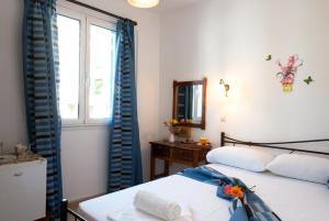 sypialnia z 2 łóżkami i oknem w obiekcie Hotel Kyma w mieście Skala Eresou