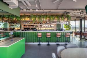 a green bar with pink stools in a restaurant at The Social Hub Florence Lavagnini Extended Stay in Florence