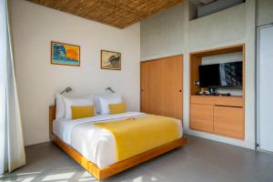 a bedroom with a large bed and a tv at Atap Resort Canggu by Ini Vie Hospitality in Canggu +25 photos