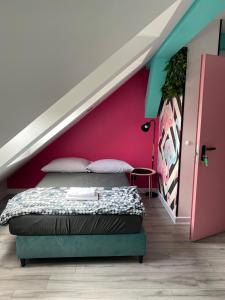 a bedroom with a bed and a pink wall at Vice City Hostel District 2 in Wrocław