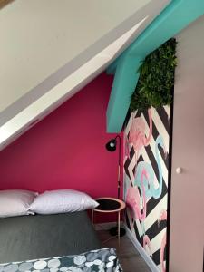 a room with a bed and a pink wall at Vice City Hostel District 2 in Wrocław +4 photos