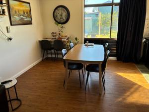 a dining room with a table and chairs and a clock at Jerilderie BNB - Pets Welcome - House in Jerilderie