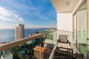 an apartment balcony with a view of the ocean at Wongamat Tower by Pattaya Sunny Rentals in North Pattaya