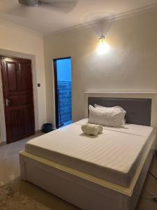 a bedroom with a large white bed with a window at Cozy Stay Near Zanzibar Airport in Zanzibar City