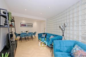 un salon avec un canapé bleu et une table dans l'établissement Bon Accord Square - SJA Stays - Modern 3 Bed Apartment, à Aberdeen