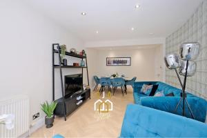 un salon avec un canapé bleu et une table dans l'établissement Bon Accord Square - SJA Stays - Modern 3 Bed Apartment, à Aberdeen