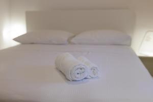 a roll of white towels sitting on a bed at Apartmani Spajić Duboka by aneo travel in Klek