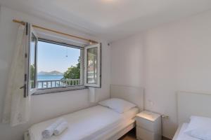 a white room with a window and a bed with a view at Apartmani Spajić Duboka by aneo travel in Klek +17 photos