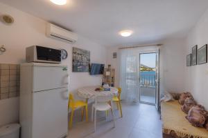 a kitchen with a white refrigerator and a table with chairs at Apartmani Spajić Duboka by aneo travel in Klek