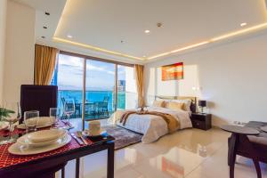 a bedroom with a bed and a view of the ocean at Wongamat Tower by Pattaya Sunny Rentals in North Pattaya