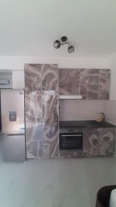 a kitchen with a counter with a refrigerator and a microwave at Apartment Cica in Igalo