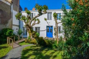 eine Außenansicht eines weißen Hauses mit einer blauen Tür in der Unterkunft Maison bourgeoise - centre ville - 7 personnes in Les Sables-dʼOlonne