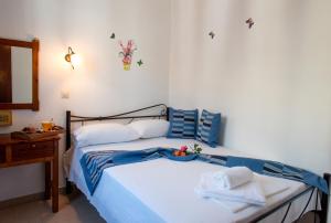 a bedroom with a bed with blue and white sheets at Hotel Kyma in Skala Eresou
