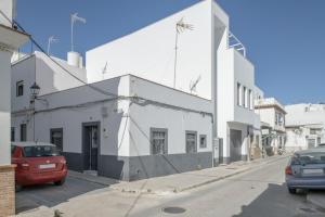 un edificio blanco al costado de una calle en Casa Pepa, en Barbate