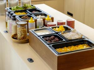 a buffet with several trays of food on a counter at Hotel Wing International Premium Kanazawa Ekimae in Kanazawa +226 photos