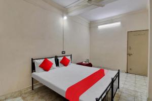 a bedroom with a large bed with red pillows at Hotel O Kr Inn in Chandrapur