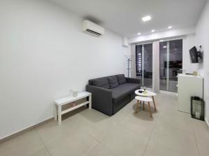 a living room with a couch and a table at APOLLON Suites by SDR in Paralia Katerinis