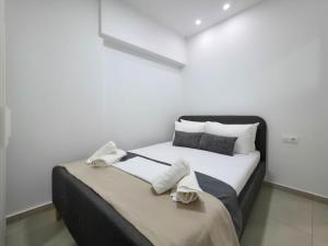 a bedroom with a bed with towels on it at APOLLON Suites by SDR in Paralia Katerinis