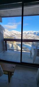 a room with a view of a snow covered mountain through a window at Studio LE CORBIER in Villarembert