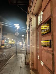 a city street at night with a sign on the side of a building at Hotel BABU in Kutaisi