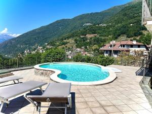 a swimming pool on a patio with mountains in the background at Casa Juliette in Bellano