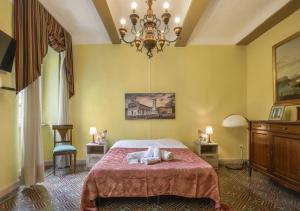 a bedroom with a bed and a chandelier at Fantastico Appartamento Lucca Centro Storico in Lucca