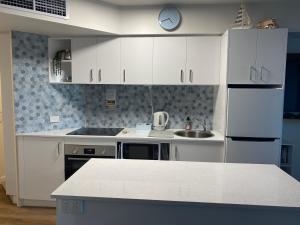 a kitchen with white cabinets and a counter top at Just Perfect Apartment with Ocean Views in Caloundra