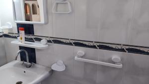a white bathroom with a sink and a mirror at Maison Sérénité Campagne in Hammamet Sud +6 photos