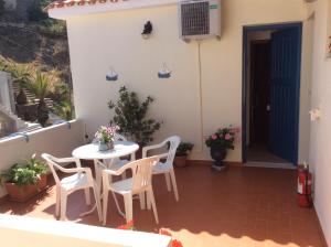 a patio with a table and chairs on a balcony at Hotel Kyma in Skala Eresou