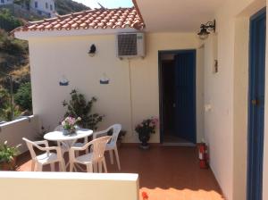 a patio with a table and chairs on a balcony at Hotel Kyma in Skala Eresou