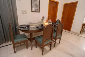 a dining room with a table and chairs with candles at Kutani Stays - Civil Lines in Jaipur
