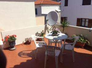 a patio with a table and chairs on a balcony at Hotel Kyma in Skala Eresou