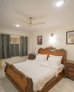 a bedroom with a large wooden bed with white pillows at Kutani Stays - Civil Lines in Jaipur