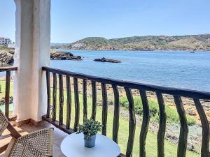 a balcony with a table and a view of the water at Roca Fornells, P131 in Fornells